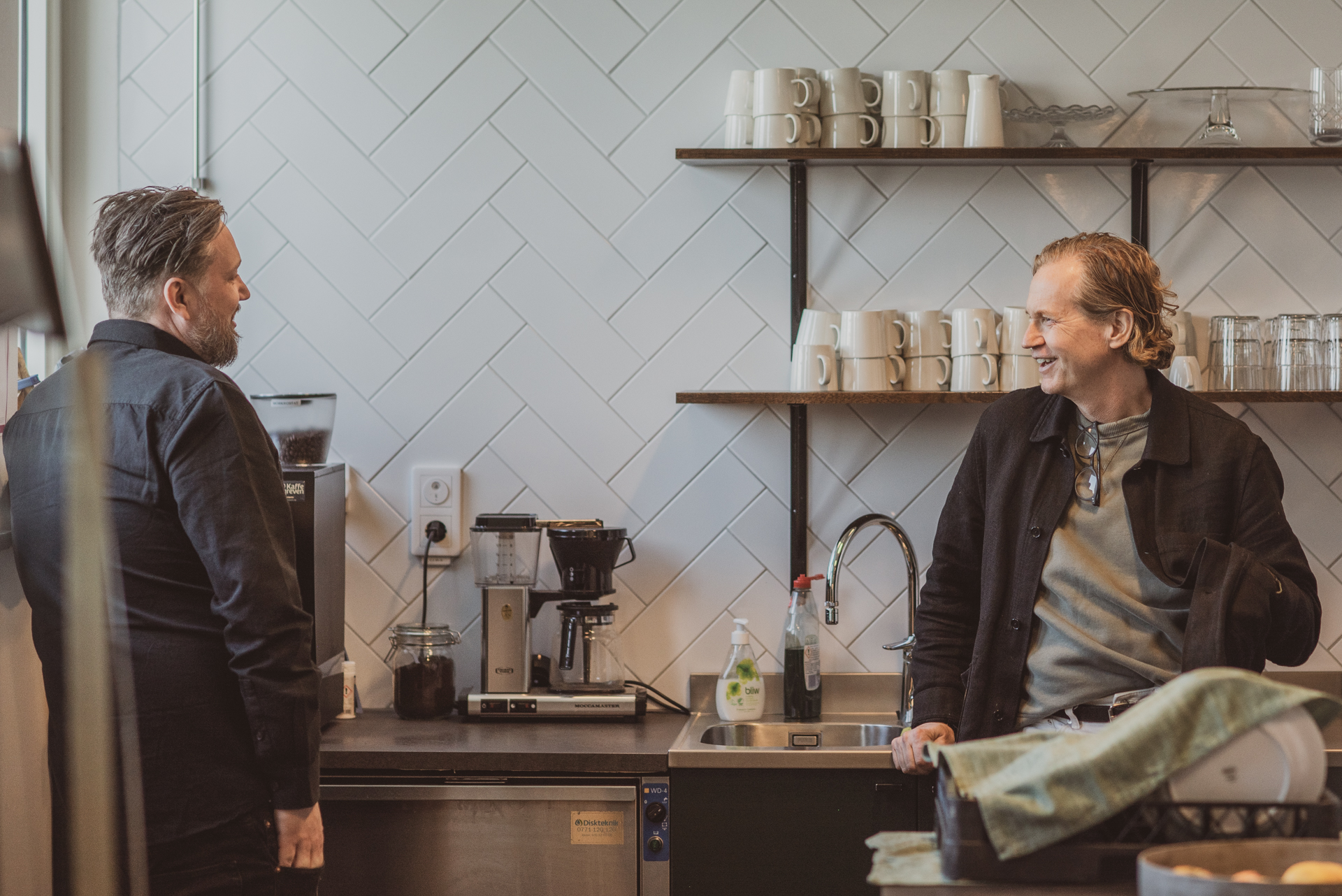 Två män på Valentin Experience fullservicebyrå hämtar kaffe i köket